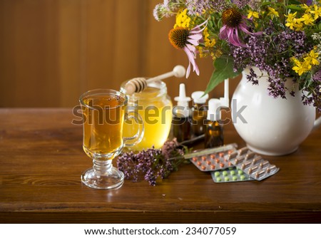 Still life from medicinal herbs, honey, herbal tea and medicines on a wooden background