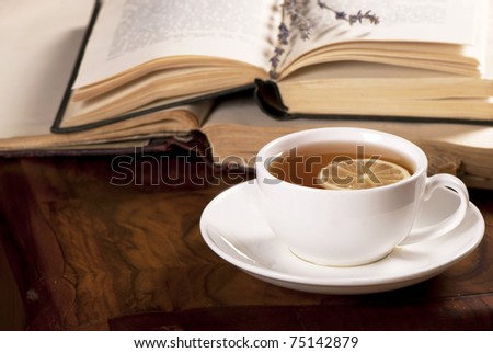 book, tea on wooden board