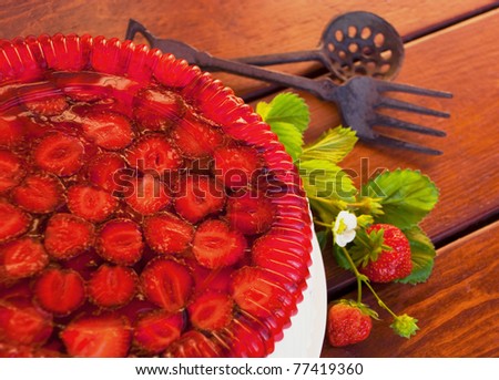 Pie the decorated jelly from a strawberry on a wooden table