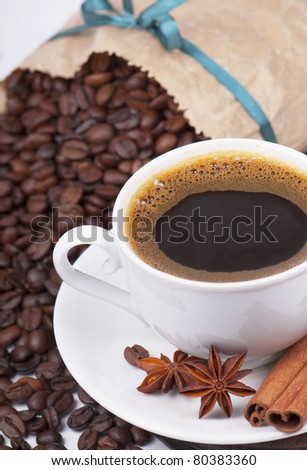 Cup of coffee, coffee grains in a paper package with a tape and spices