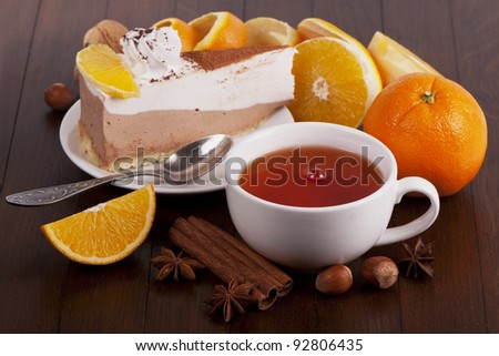 Cake, spoon, white cup of tea, orange, cinnamon and anise