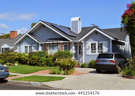 Modern house with garden, chimney and solar panels on the gable roof. LA, CA .
