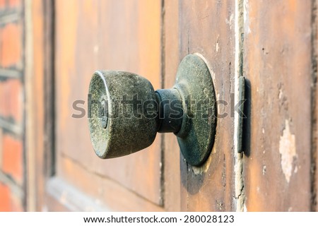 Rustic door knob and keyhole on the old wooden door.