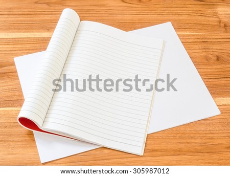 Open empty book with paper on wood board.
