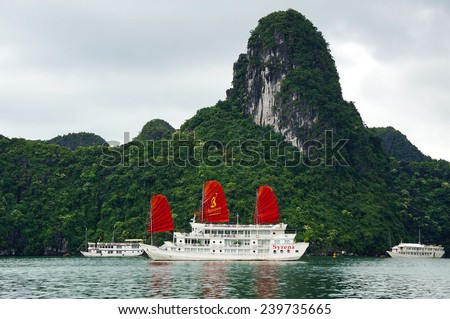 HA LONG BAY, VIETNAM - SEPT 01, 2013: Exotic cruise boat with red sails carrying tourists in Ha Long Bay. The popular destination is recognized as a UNESCO World Heritage Site.