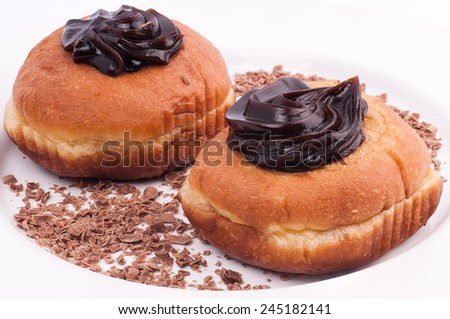 Chocolate donuts and chocolate flakes on a white plate isolated on white background