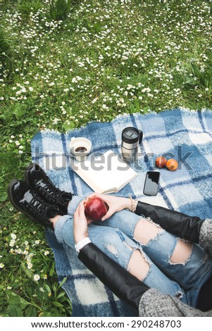 Girl with ripped jeans during a picnic in a garden
