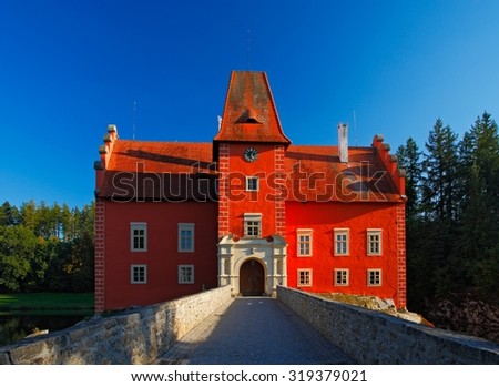 Fairy tale red castle on the lake with bridge, with dark blue sky, state castle Cervena Lhota, Czech republic