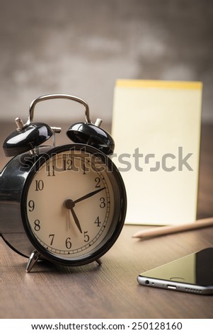 Black alarm clock with phone and notepad