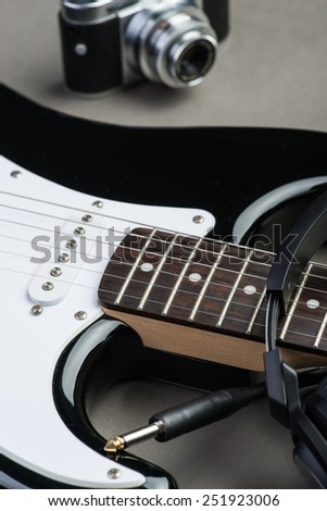 Black and white guitar frets with vintage photo camera and headphones