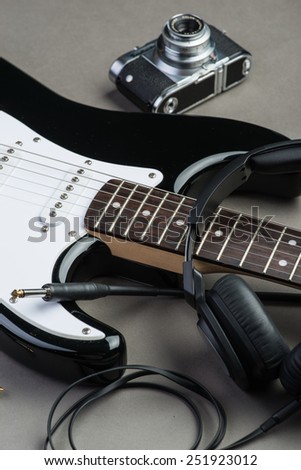 Black and white guitar frets with vintage photo camera and headphones