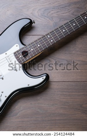 Electric guitar with mediator on a brown wooden floor