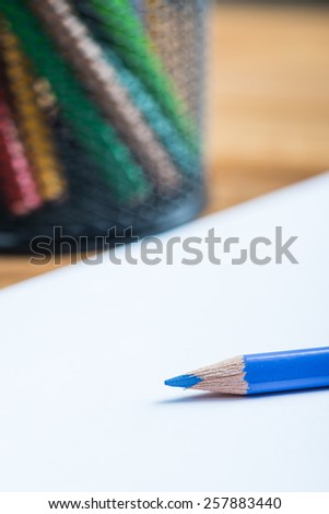 Bunch of color pencils with a white paper sheet