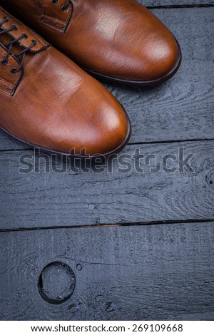 Brown leather shoes on a black wooden floor