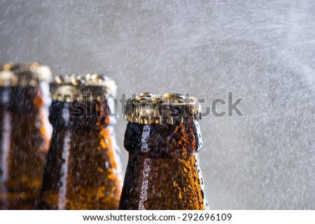 Ice cold beer bottles with drops of dew over the grey background