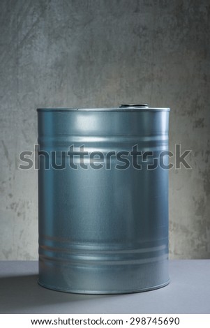 Grey metal oil and chemical drum over the white concrete wall background