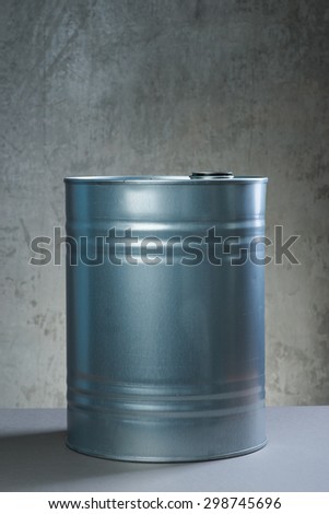 Grey metal oil and chemical drum over the white concrete wall background