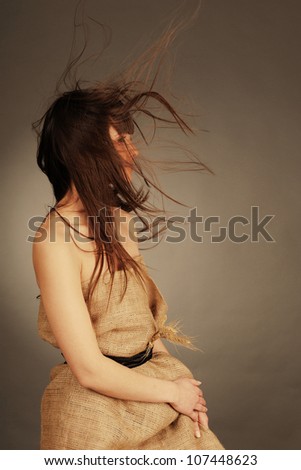 Beautiful young woman with fluttering hair and wheat ears. Nature  concept.