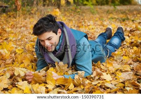 Young dreaming man in autumn park.