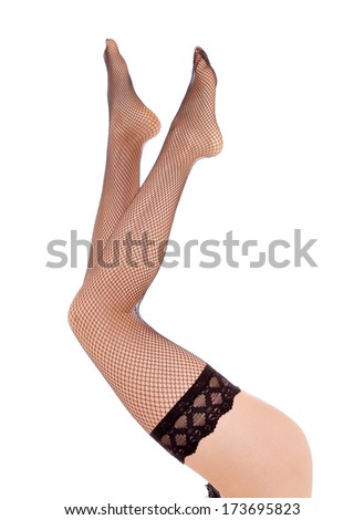 Female legs in black net pantyhose, isolated on white.