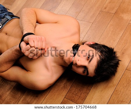 Binding young man laying on a floor looking at camera.