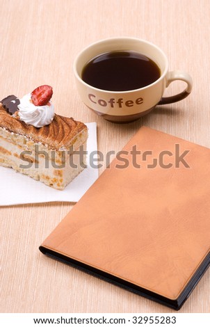 Biscuit cake with cup of coffee and book