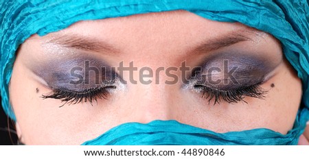 Closeup of closed woman\'s eyes with east make-up