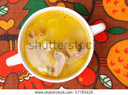 Bowl of Chicken Soup with Mushrooms on a color ethnic background