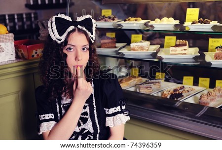 Young beautiful woman with cakes in cafe.