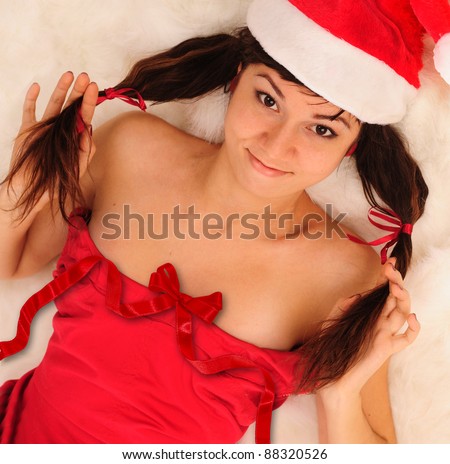 Portrait of smiling girl with funny dual pony tails hairstyle, dressed in Santa hat.
