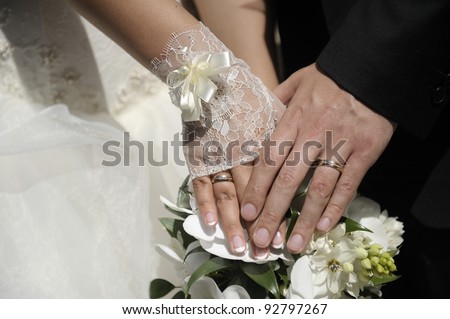 Just married couple hands with flowers.