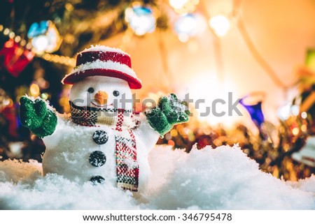 Snowman stand among pile of snow at silent night with a light bulb, light up the hopefulness and happiness in Merry christmas and new year night.