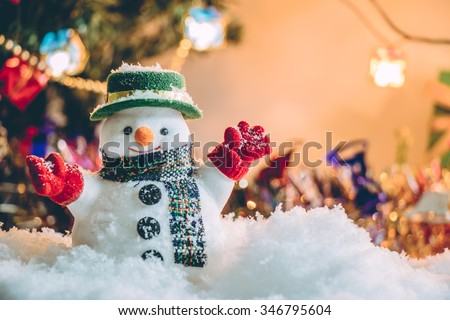 Snowman stand among pile of snow at silent night with a light bulb, light up the hopefulness and happiness in Merry christmas and new year night.