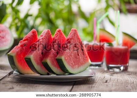 fresh sliced watermelon and watermelon smoothie on a wooden table