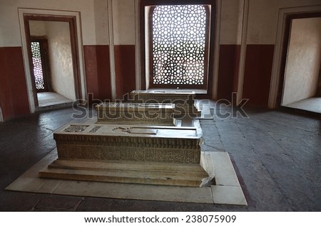 Delhi, India - Apr 27 2014: Inside the Humayun\'s Tomb, 3 stone tombs are located in one room, sunshine is coming through the beautiful windows in islamic style.
