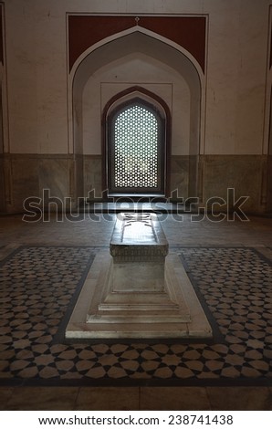 Delhi, India - Apr 27 2014: Inside the Humayun\'s Tomb, 1 stone tomb is located in the middle of one room, sunshine is coming through the beautiful windows in islamic style.