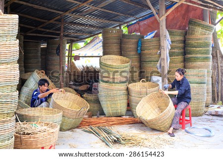 Vinh Long city, Vietnam - 06 May 02, 2015: Unknown, An Asian woman weaving handicraft basket from bamboo. The fruit trader on floating market in the Mekong Delta will need the baskets like these