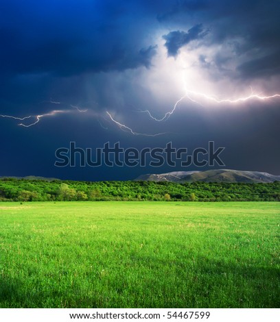 Thunderstorm with lightning  in green meadow. Nature composition.