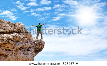 Man on the edge of cliff. Emotional scene. - stock photo
