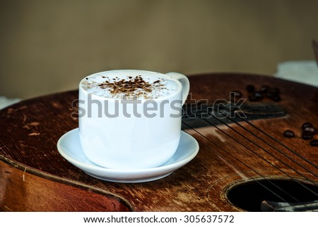 Coffee cup, coffee beans and guitar