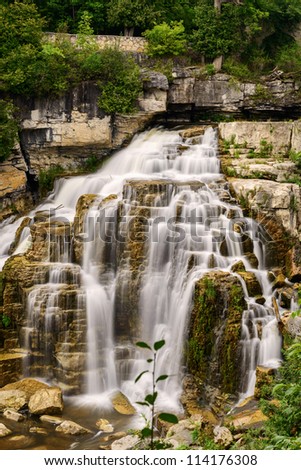 Inglis Falls in Owen Sound Ontario Canada. The Sydenham Rivers pours over rock formation of limestone shelves creating an 18 meter high cascade that has carved a deep gorge at the base of falls.