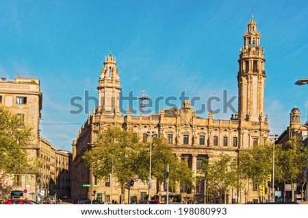 Barcelona, Spain - April 6: Early morning traffic at historic public office building at Antonio Lopez Plaza in Barcelona, Spain on April 6, 2014.