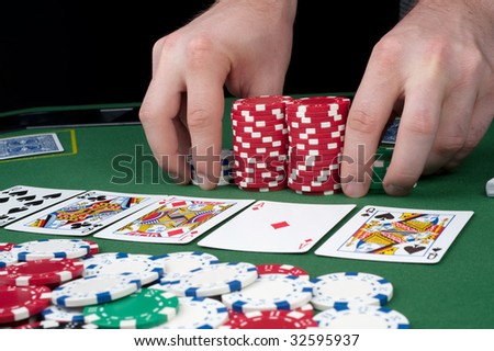 All in motion with five cards face up in front of a pot of chips