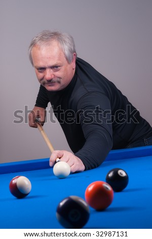 man shooting balls at a billiards hall on a blue felt table