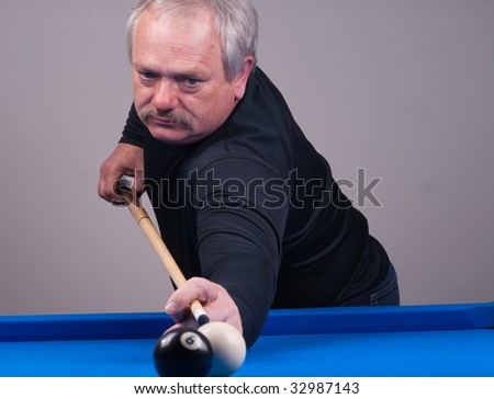 person taking a shot playing billiards on a blue felt table