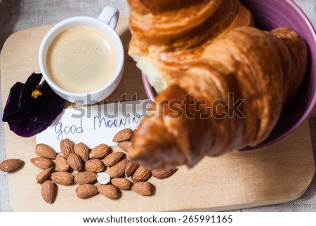Breakfast with croissants almonds and good morning note
