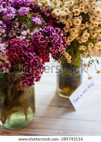 White and pink flowers in glass jars and \