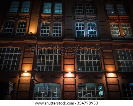 Windows on a brick wall a old fashioned business-building with night illumination