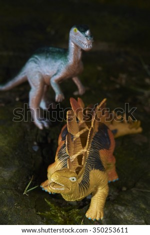 Toy dinosaur figurine in a real nature scenery outdoors