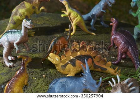 Group of Toy dinosaurs figurine in a real nature scenery outdoors